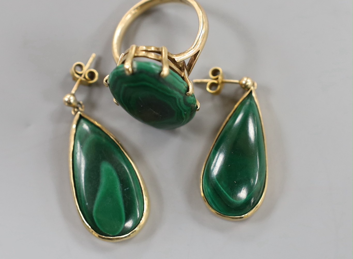 A 9ct gold and malachite set oval ring, size P/Q and a pair of similar earrings, gross weight 20.4 grams.